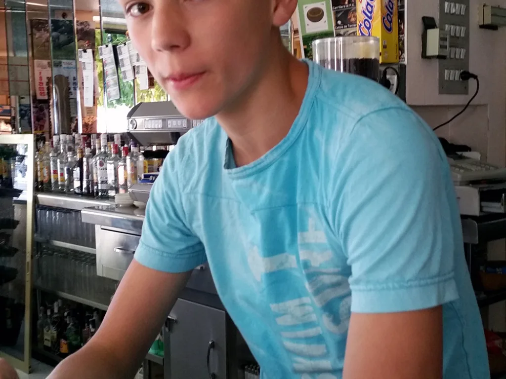 Ein Jugendlicher arbeitet hinter dem Tresen einer Bar.